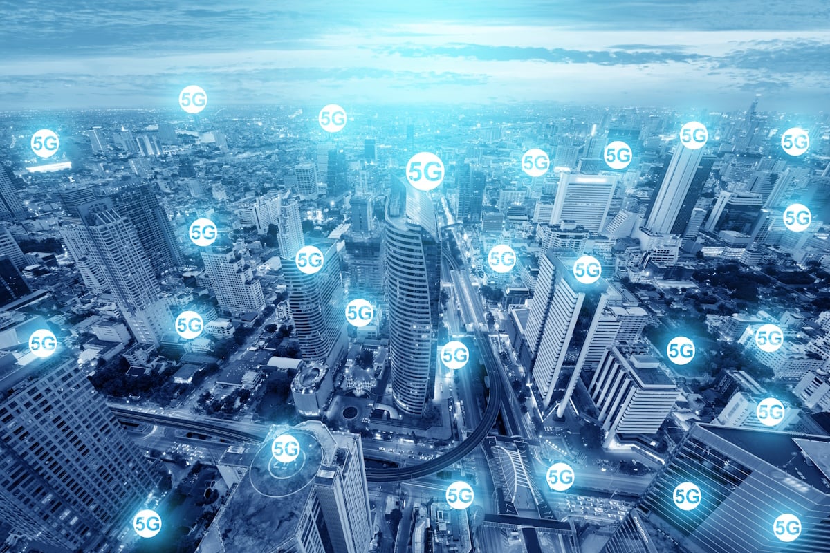 城市景观视图上覆盖着多个发光的“5G”图标，表明下一代移动网络覆盖在城市环境中的广泛可用性。
